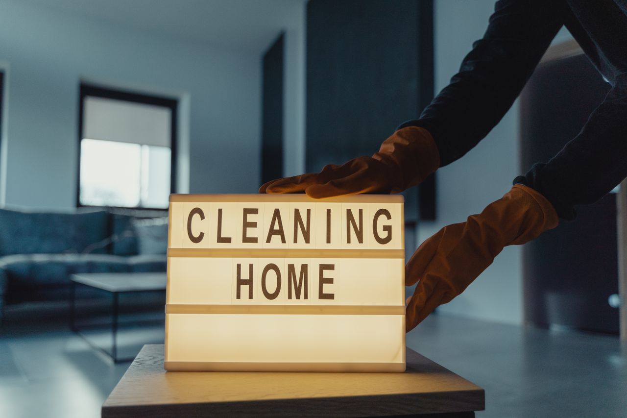 Mastering the First Impression: Your intriguing post title goes here Close-up of hands with rubber gloves holding an illuminated lightbox saying 'Cleaning Home'.